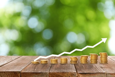 Image of Stacked coins on wooden table against blurred background. Investment concept