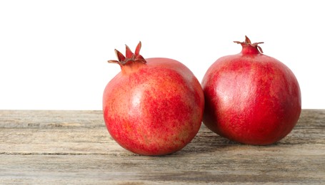 Photo of Fresh pomegranates on wooden table against white background, space for text