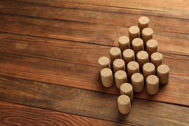 Photo of Christmas tree made of wine corks on wooden table. Space for text