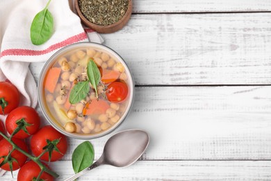 Photo of Flat lay composition of tasty chickpea soup in bowl and spices served on white wooden table. Space for text
