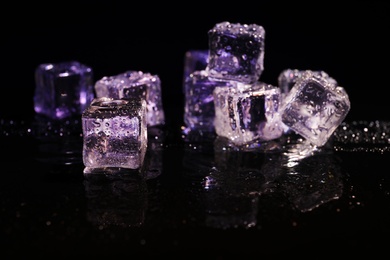 Photo of Pile of crystal clear ice cubes on black background
