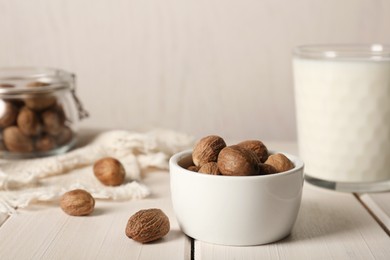 Photo of Nutmegs in bowl on white wooden table