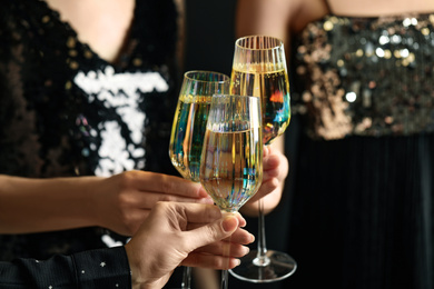 Photo of Women clinking glasses of champagne at party, closeup