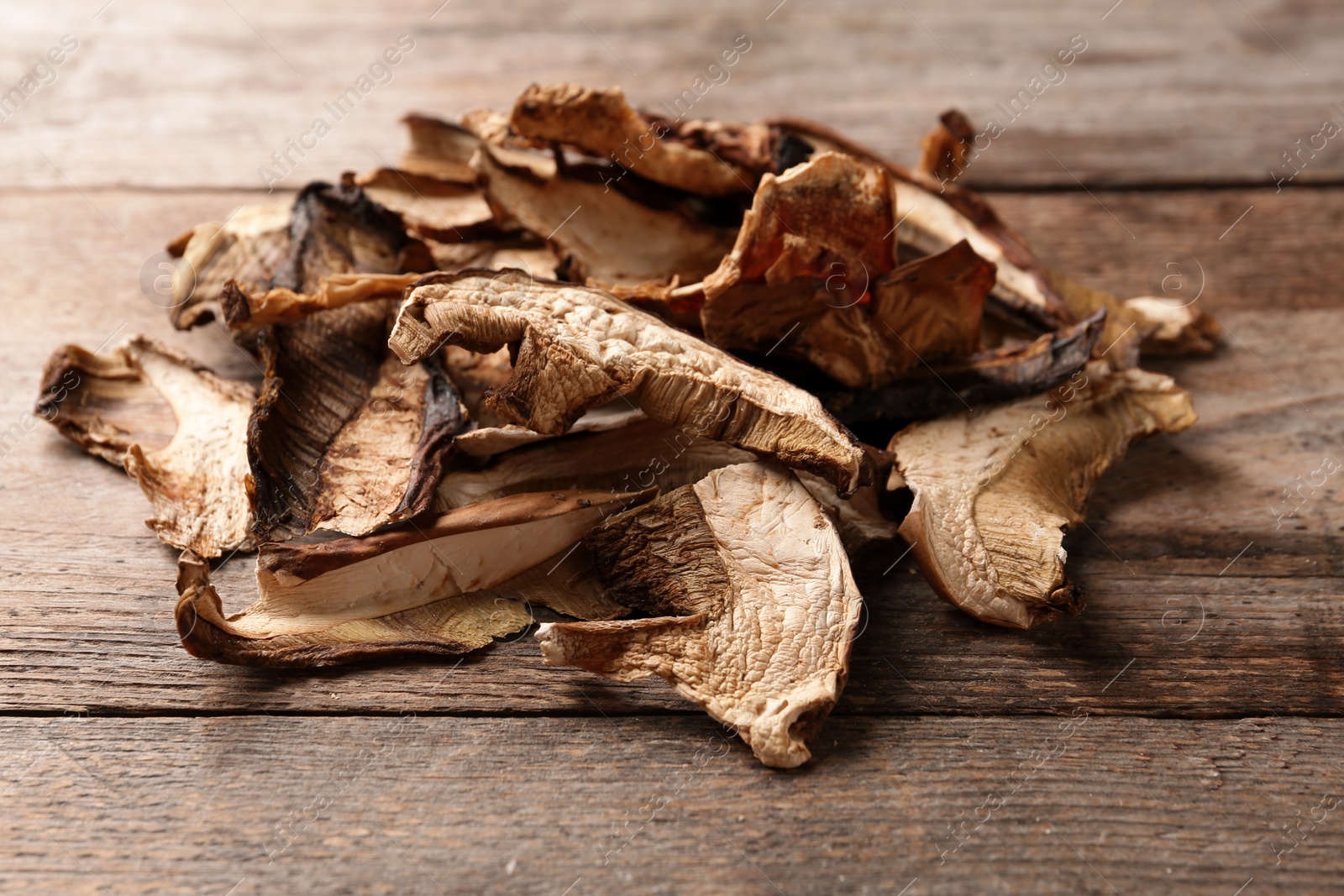 Photo of Delicious dried mushrooms on wooden background, closeup