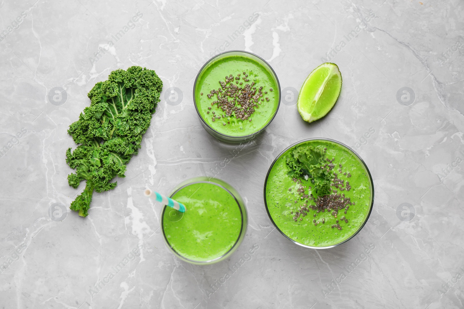 Photo of Tasty kale smoothie on light grey marble table, flat lay