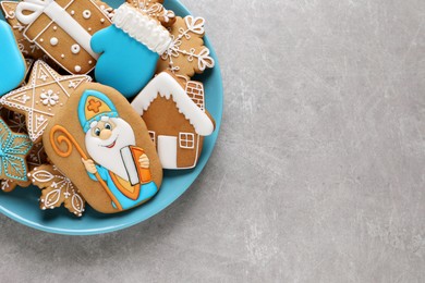 Photo of Tasty gingerbread cookies and space for text on light grey table, top view. St. Nicholas Day celebration