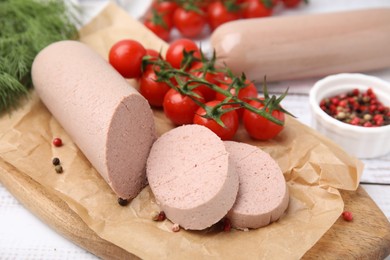 Photo of Delicious liver sausages and other products on white wooden table, closeup