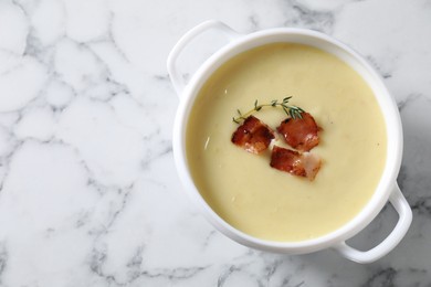 Photo of Tasty potato soup with bacon and rosemary in bowl on white marble table, top view. Space for text