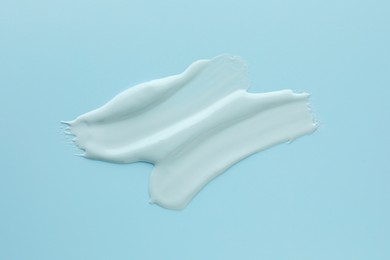 Photo of Samples of face mask on light blue background, top view