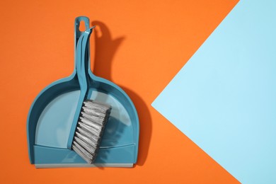 Photo of Plastic hand broom and dustpan on color background, top view. Space for text
