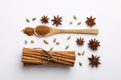 Photo of Cinnamon sticks, star anise and cardamom pods on white background, flat lay
