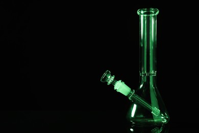 Photo of Glass bong on black background, space for text. Smoking device