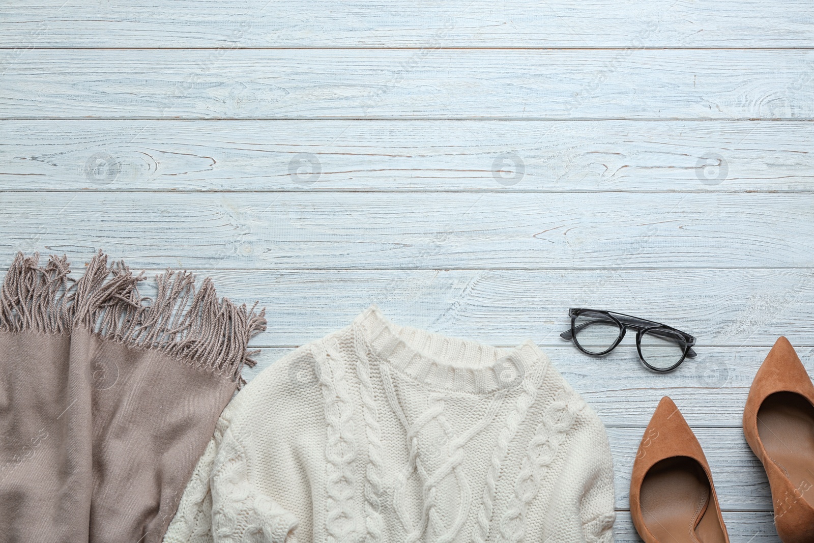 Flat lay composition with warm clothes on white wooden background. Space for text Photo of Flat lay composition with warm clothes on white wooden background. Space for text