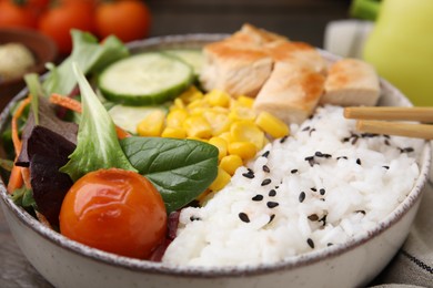 Photo of Delicious poke bowl with meat, rice, vegetables and greens on table, closeup