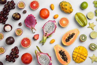 Photo of Many different delicious exotic fruits on light background, flat lay