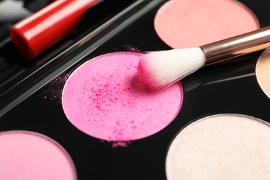 Photo of Colorful eyeshadow palette with brush, closeup view