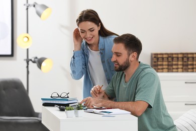 Photo of Young couple discussing family budget at home