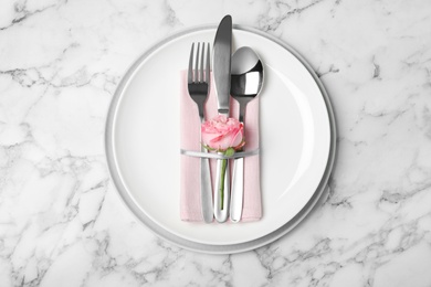 Photo of Beautiful table setting with cutlery, napkin and plates on marble background, top view
