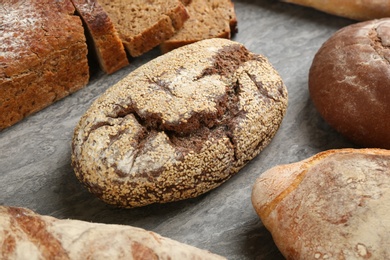 Photo of Different kinds of fresh bread on grey table