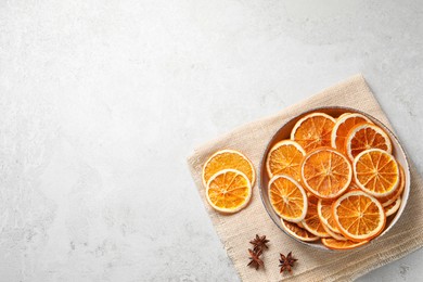 Photo of Dry orange slices and anise stars on light table, top view. Space for text