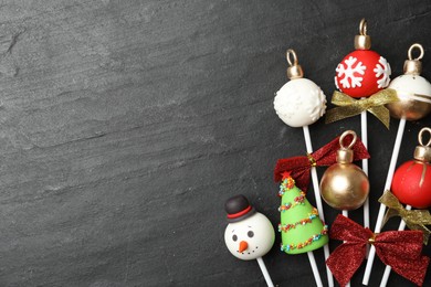 Photo of Delicious Christmas themed cake pops on black table, flat lay. Space for text