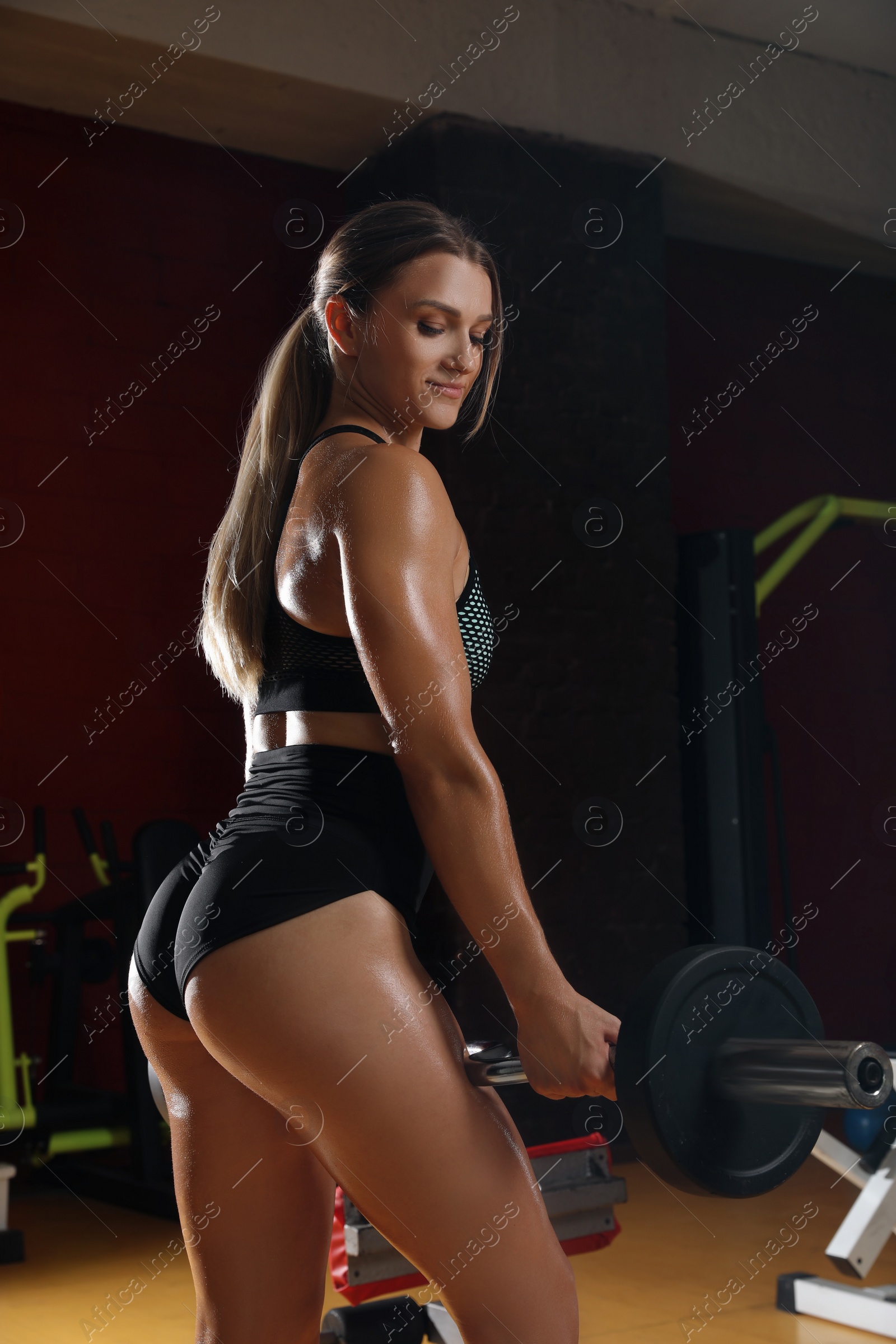 Photo of Woman with barbell training in modern gym