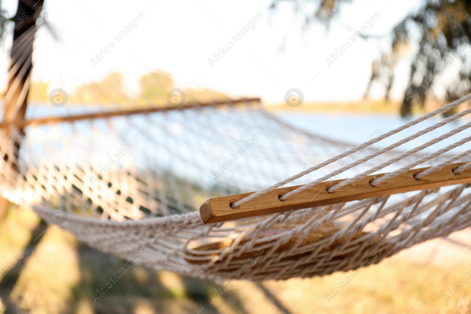 Photo of Hat in comfortable hammock on beach, closeup. Summer vacation