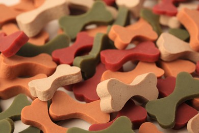 Photo of Many bone shaped vitamins for pets as background, closeup