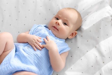 Photo of Cute little baby lying in crib at home