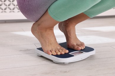 Photo of Woman on floor scale at home, closeup. Weight control