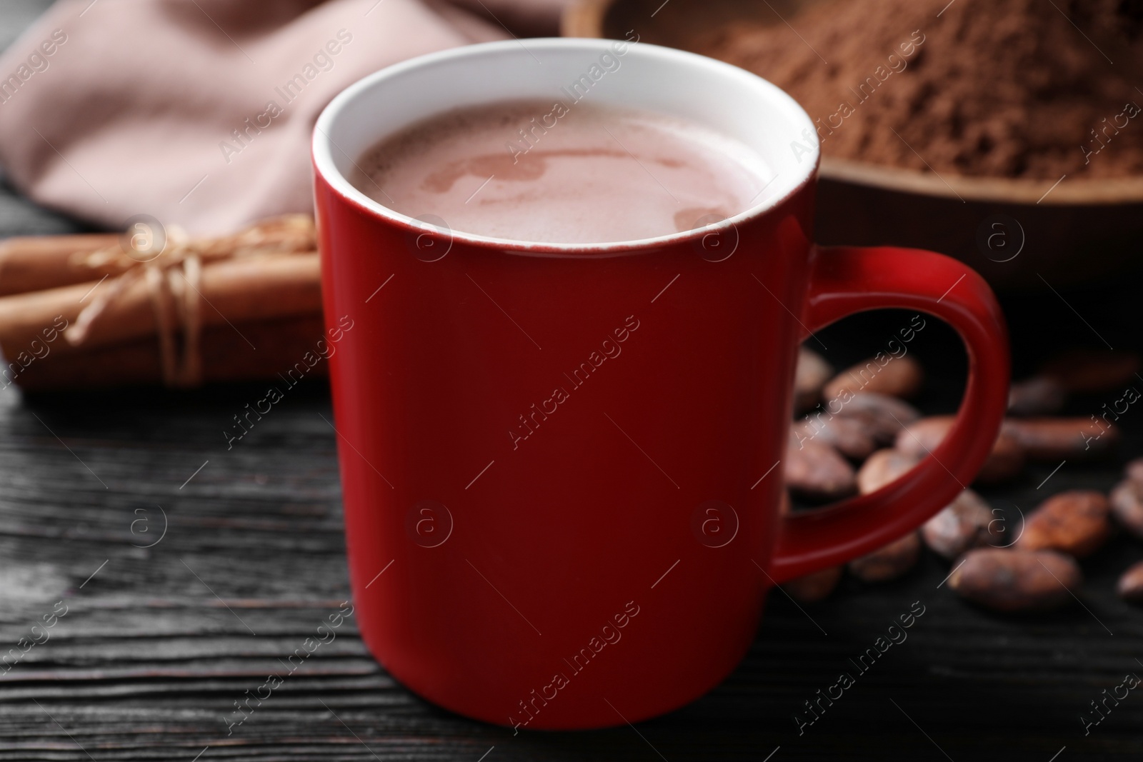 Photo of Cup of tasty cocoa on black wooden table