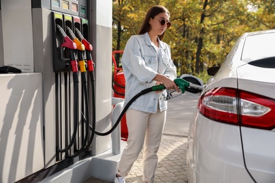 Photo of Woman refueling car at self service gas station