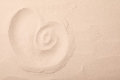 Photo of Nautilus shell print on sand, top view. Space for text