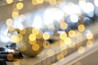 Image of Christmas and New Year music. Piano with festive ball, bokeh effect