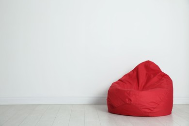 Photo of Red bean bag chair near white wall in room