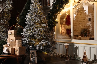 Photo of Beautiful Christmas trees, gift boxes, skates and festive decor indoors. Interior design