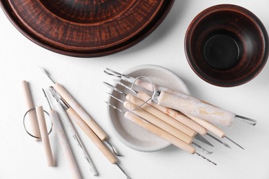 Set of different clay crafting tools on white table