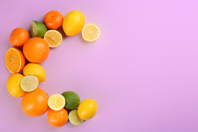 Photo of Letter C made with citrus fruits on lilac background as vitamin representation, flat lay. Space for text