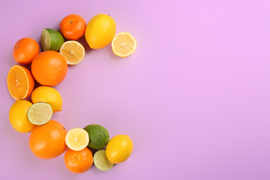 Letter C made with citrus fruits on lilac background as vitamin representation, flat lay. Space for text