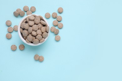 Photo of Beer yeast pills on light blue background, flat lay. Space for text