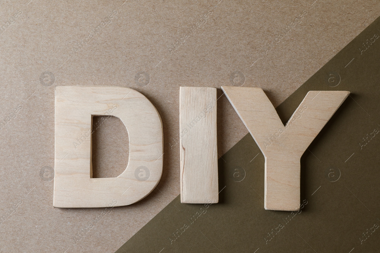 Photo of Abbreviation DIY made of wooden letters on color background, flat lay
