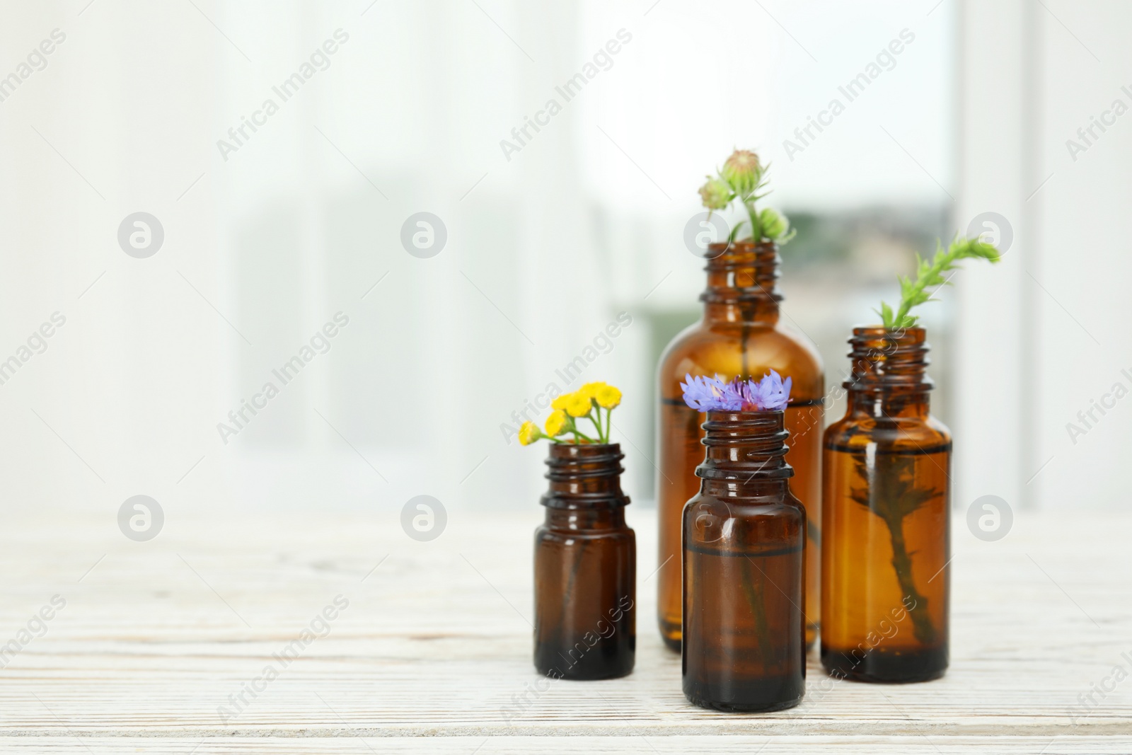 Photo of Composition with essential oils and flowers on table