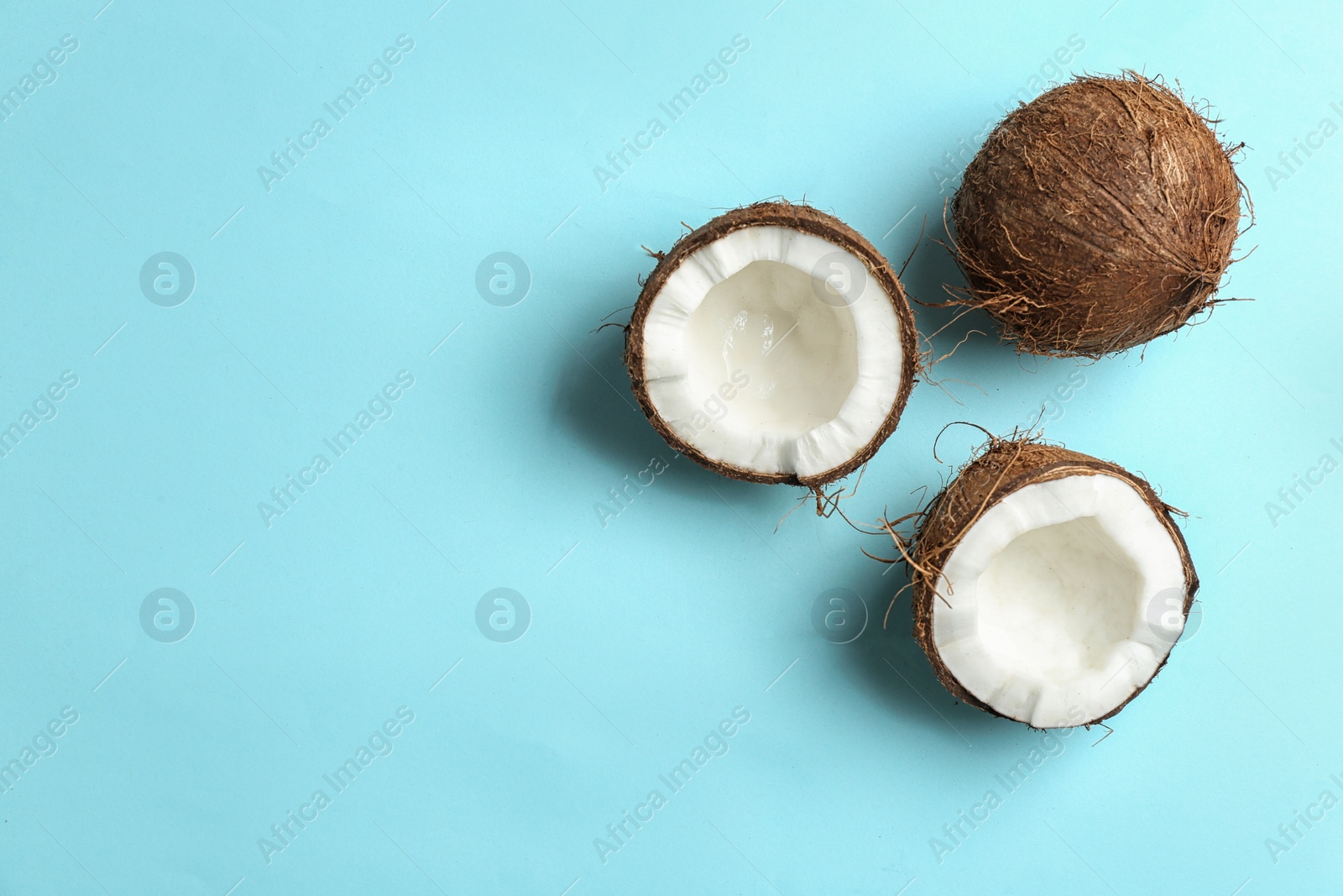 Photo of Flat lay composition with coconuts on color background. Space for text