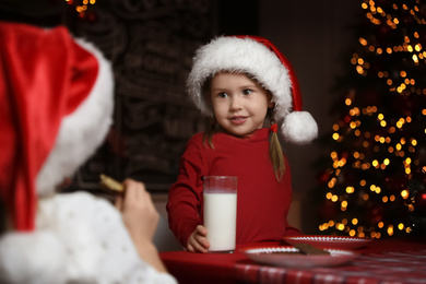 Photo of Cute little children at table in dining room. Christmas time