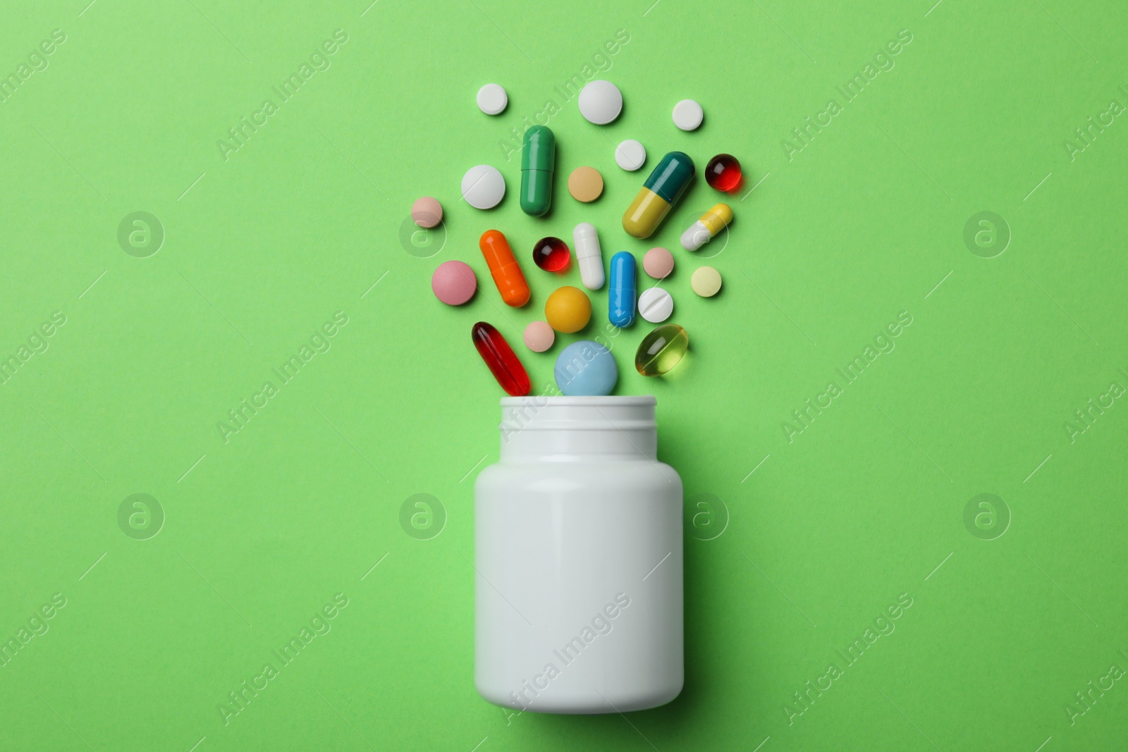 Photo of Bottle with different pills on color background, flat lay