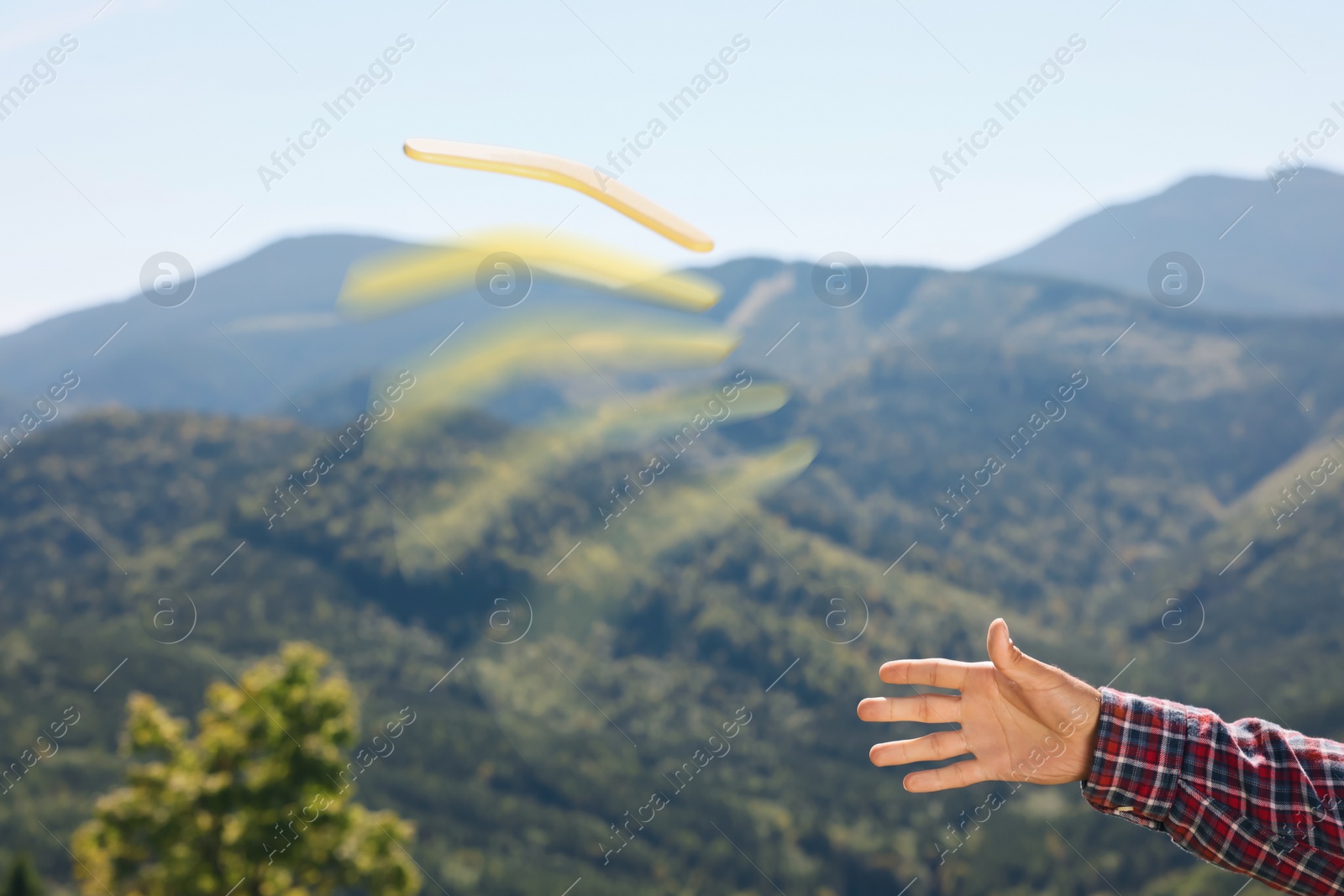 Image of Man throwing boomerang in mountains, closeup view