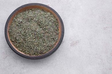 Plate with dried thyme on grey table, top view. Space for text