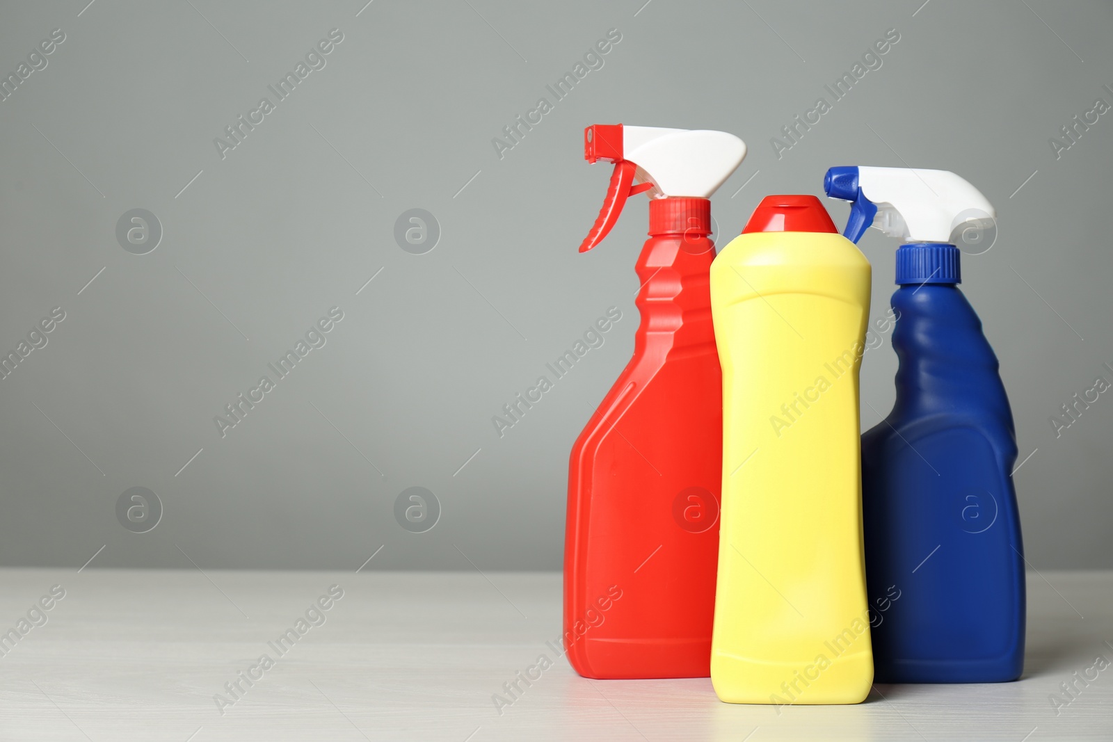 Photo of Different cleaning products on light table. Space for text