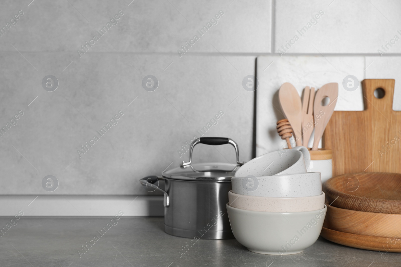 Photo of Cooking utensils and other kitchenware on grey countertop. Space for text