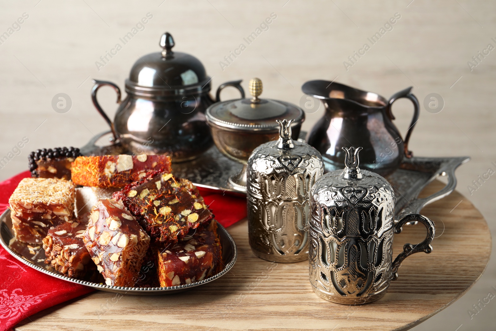 Photo of Tea and Turkish delight served in vintage tea set on wooden table